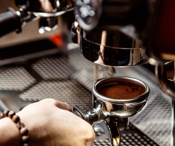 man makes coffee in a coffee machine